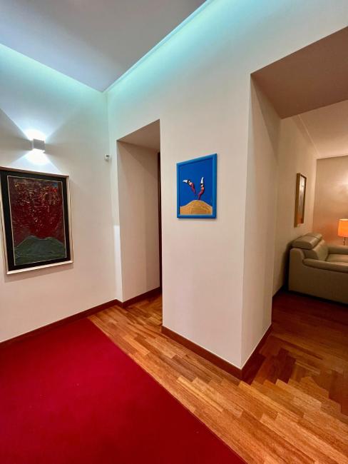 Corridoio interno con parquet e opere alle pareti